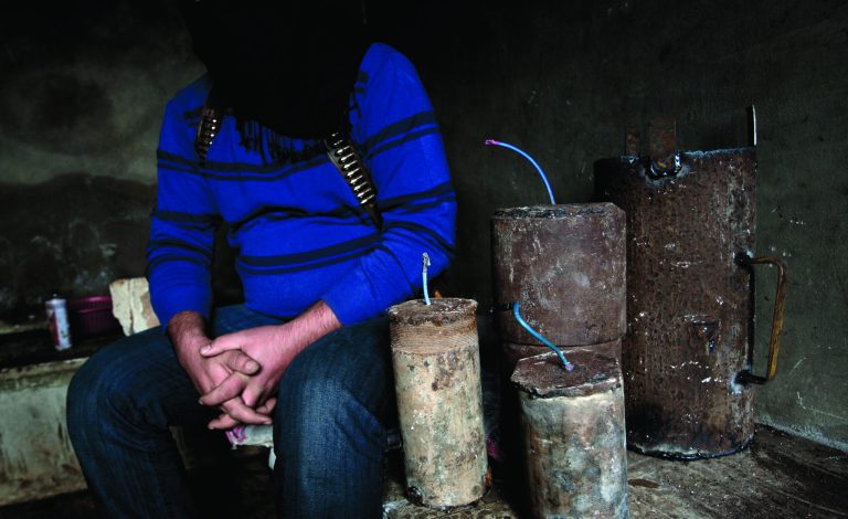 In this Friday, Dec. 14, 2012, Syrian rebel bomb maker Abu Moawiya sits next to bombs as he waits for other rebels to transfer them to another location, at their post in Maaret Misreen, near Idlib, Syria. The new Syrian rebel chief, a defected army general who spent months in exile, says he has begun operating inside Syria to unite autonomous anti-regime militias for what he hopes will be the final push against President Bashar Assad. (AP Photo/Muhammed Muheisen)