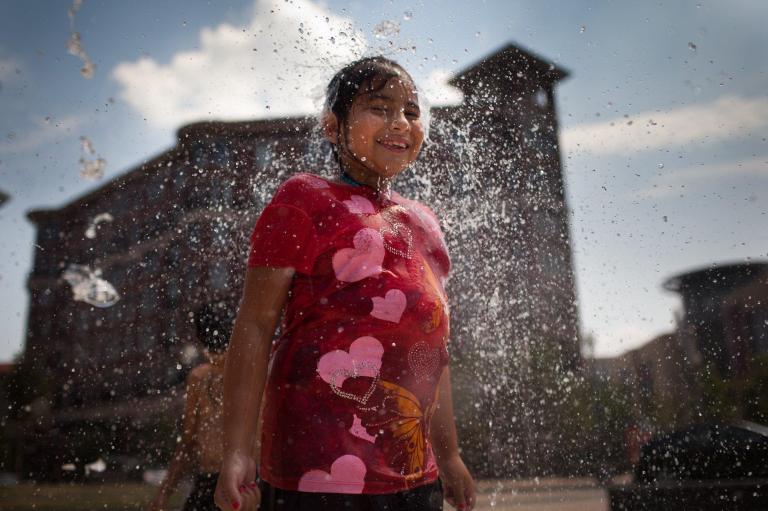 Keiry Fuentes cools off at a fountain in Columbia Heights, Washington, D.C. Temperatures in the Washington region reached 100 degrees during the day on Tuesday, July 17, 2012. (Graeme Jennings/Examiner)