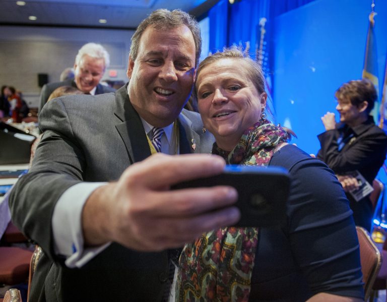 New Jersey Gov. Chris Christie takes a cell phone photo with NGA staffer Lily Kersh of Little Rock, Ark., during the National Governor's Association Winter Meeting in Washington, Saturday, Feb. 22, 2014. (AP Photo/Cliff Owen)