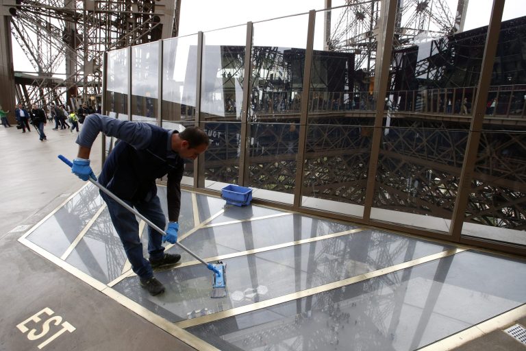 A worker cleans the new glass floor at The Eiffel Tower during the inauguration of the newly refurbish first floor, in Paris, France, Monday, Oct. 6, 2014. Visitors of the Eiffel Tower can walk on a transparent floor at 188 feet high and look down through solid glass, with safety glass barriers around the edge. (AP Photo/Francois Mori)