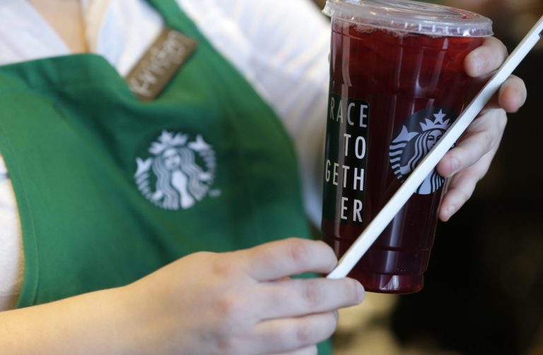 A barista holds a Starbucks drink with a 