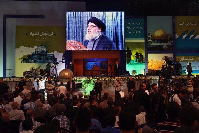 Supporters listen as Hezbollah leader Sheik Hassan Nasrallah, center, speaks during a rally to mark Jerusalem Day or Al-Quds Day, in suburb of Beirut, Lebanon, Friday, July 25, 2014. Nasrallah said that the 