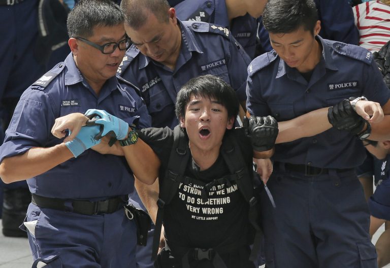A student is taken away by policemen at the government headquarter  in Hong Kong, Saturday, Sept. 27, 2014. Riot police in Hong Kong on Saturday arrested scores of students who stormed the government headquarters compound during a night of scuffles to protest China's refusal to allow genuine democratic reforms in the semiautonomous region.(AP Photo/Vincent Yu)