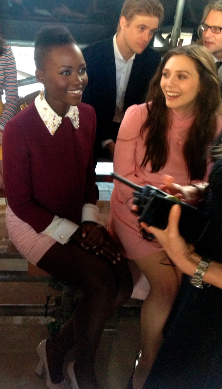 Actresses Lupita Nyong'o, left, and Elizabeth Olsen attend Miu Miu's ready to wear fall/winter 2014-2015 fashion collection presented in Paris, Wednesday, March 5, 2014. (AP Photo/Thomas Adamson)