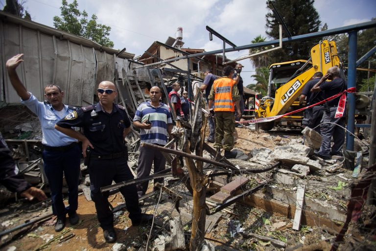 Israeli police officers secure a destroyed house that was hit by a rocket fired by Palestinians militants from Gaza, in Yahud, a Tel Aviv suburb near the airport, central Israel, Tuesday, July 22, 2014. As a result, Delta Air Lines and U.S. Airlines decided to cancel their scheduled flights to Israel.(AP Photo/Dan Balilty)