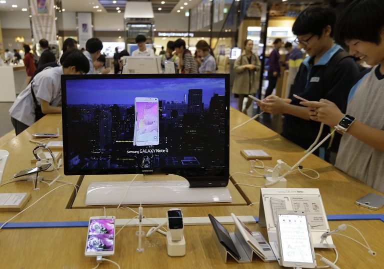 Middle school students try out Samsung Electronics' Galaxy Note 4 at the company's showroom in Seoul, South Korea, Tuesday, Oct. 7, 2014. Samsung Electronics Co. said Tuesday its third-quarter operating profit is estimated to have fallen to the lowest level in more than three years, as Galaxy handsets sales slow. (AP Photo/Ahn Young-joon)