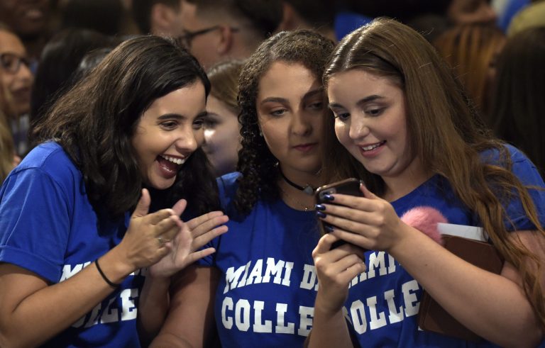 Three girls look at the photo they took with President Barack Obama after Obama spoke about the Affordable Care Act, Thursday, Oct. 20, 2016, at Miami Dade College in Miami. The president is promoting his health overhaul by saying that never in U.S. history has the uninsured rate been lower than it is today. (AP Photo/Susan Walsh)