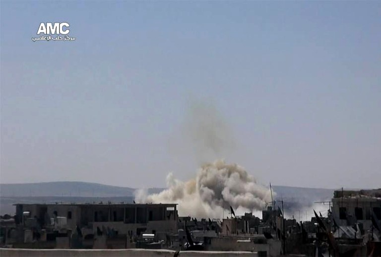 This photo provided by the anti-government activist group Aleppo Media Center (AMC), which has been authenticated based on its contents and other AP reporting, shows smoke rising from a Syrian government forces airstrike in Aleppo, Syria, Tuesday, June 17, 2014. A car bomb exploded in eastern Syria near the border with Iraq on Tuesday, killing many people, including a local rebel commander, opposition activists said. (AP Photo/Aleppo Media Center AMC)