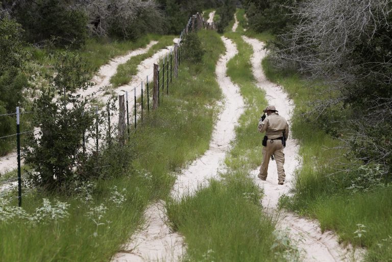 FILE - In this Sept. 5, 2014 file photo, a U.S. Customs and Border Protection Air and Marine agent looks for signs along trail while on patrol near the Texas-Mexico border near McAllen, Texas. President Barack Obama, who has postponed until after Election Day his plan for executive actions that could shield millions of immigrants from deportation, is already on pace this year to deport the fewest number of immigrants since at least 2007, according to a new analysis of Homeland Security Department figures by The Associated Press.  (AP Photo/Eric Gay, File)