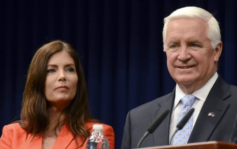 Gov. Tom Corbett and Attorney General Kathleen Kane listen during a news conference Friday, June 27, 2014, at the Capitol in Harrisburg, Pa.. Corbett and Kane announced details of an agreement to allow some Highmark insurance enrollees under certain conditions to continue using its doctors and facilities at in-network rates under a consent decree filed in court Friday, after a long and bitter fight between the two western Pennsylvania health care giants. (AP Photo/Marc Levy)