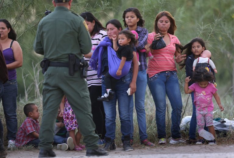 Central American immigrants await transportation to a U.S. Border Patrol processing center after crossing the Rio Grande from Mexico into the Texas on July 24, 2014 near Mission, Texas. (Photo by John Moore/Getty images)