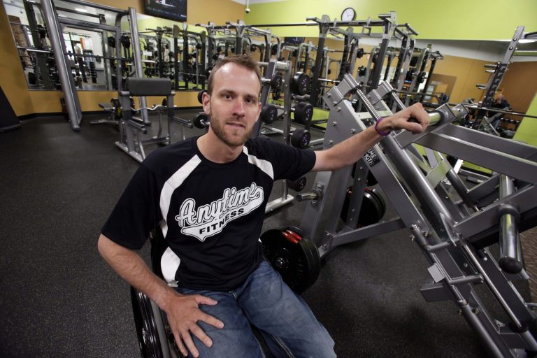In this photo taken Friday, Oct. 3, 2014, Kyle Henning poses at one of his three Minneapolis-area Anytime Fitness franchise gyms, in Farmington, Minn. Henning is continuing the expansion of his gyms in response to a 20 percent surge in business. The colder and snowier than usual winter had people with cabin fever jamming the gyms. (AP Photo/Jim Mone)