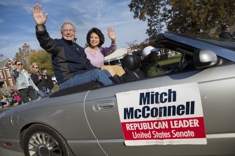 Sen. Mitch McConnell, R-Ky., and his wife, Elaine Chao, sit on the back of a convertible while attending a Veterans Day Parade on Nov. 2, 2014, in Madisonville, Kentucky. (Graeme Jennings/Examiner)