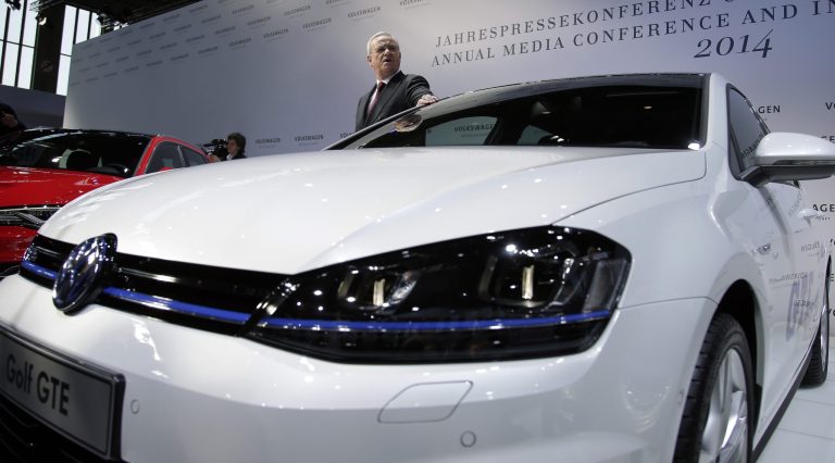 Volkswagen CEO Martin Winterkorn poses for the media next to a Golf 7 car prior to the company's annual press conference in Berlin, Germany, Thursday, March 13, 2014. German automaker Volkswagen is raising its dividend after turbocharged earnings from its Porsche luxury line outweighed slipping revenues from mass-market cars.  (AP Photo/Michael Sohn)