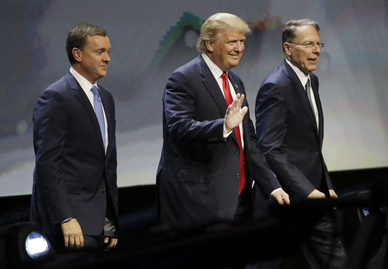Republican presidential candidate Donald Trump is introduced by National Rifle Association executive director Chris W. Cox , left, and NRA executive vice president Wayne LaPierre as he takes the stage to speak at the NRA convention, Friday, May 20, 2016, in Louisville, Ky. (AP Photo/Mark Humphrey)