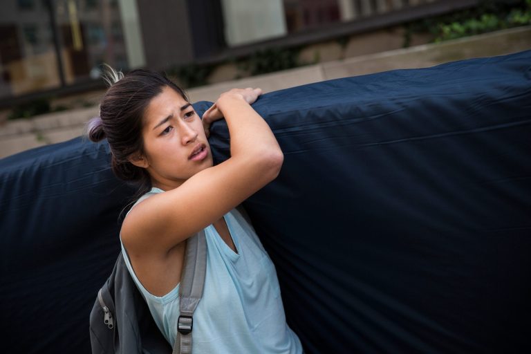 Emma Sulkowicz, a senior visual arts student at Columbia University, carries a mattress in protest of the university's lack of action after she reported being raped during her sophomore year on September 5, 2014 in New York City. (Photo by Andrew Burton/Getty Images)