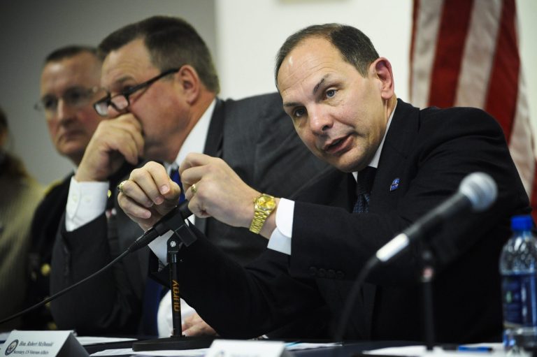 Veterans Affairs Secretary Robert McDonald, right, addresses a member of the audience's question, Tuesday, March 31, 2015, during a town hall meeting in which the secretary and Sen. Jon Tester, left, D-Mont., led a panel discussion at the Montana National Guard headquarters in Helena, Mont., near the Fort Harrison VA hospital. (AP Photo/The Independent Record, Thom Bridge)