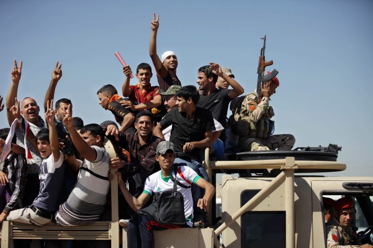 Iraqi men flash victory signs as they leave the main recruiting center to join the Iraqi army in Baghdad, Iraq, Tuesday, June 17, 2014, after authorities urged Iraqis to help battle insurgents. Hundreds of young Iraqi men gripped by religious and nationalistic fervor streamed into volunteer centers across Baghdad Saturday, answering a call by the country's top Shiite cleric to join the fight against Sunni militants advancing in the north. (AP Photo/ Khalid Mohammed)
