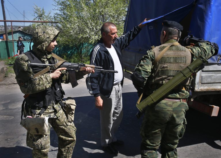 Pro Russian armed militants inspect a truck near Slovyansk, eastern Ukraine, Friday, April 25, 2014. Russian Foreign Minister Sergey Lavrov has accused the West of plotting to control Ukraine and said the pro-Russian insurgents in the southeast would lay down their arms only if the Ukrainian government clears out the Maidan protest camp in the capital Kiev. (AP Photo/Sergei Grits)
