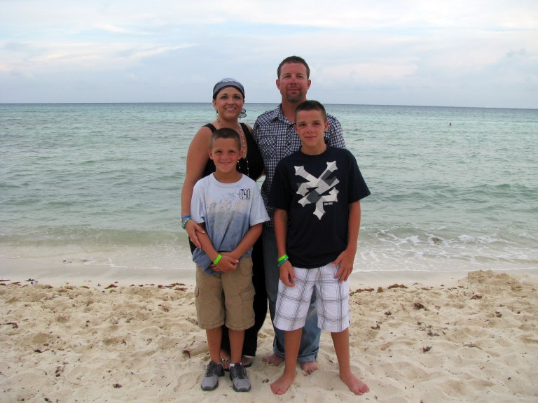 In this August 2011 photo provided by Arrica Wallace, Wallace poses with her husband, Matthew, and sons Marccus and Mason in Mexico during a vacation, two weeks after her first round of chemotherapy. Arrica Wallace was 35 when her cervical cancer was discovered in 2011. It spread widely, with one tumor so large that it blocked half of her windpipe. The strongest chemotherapy and radiation failed to help, and doctors gave her less than a year to live. But her doctor heard about an immune therapy trial at the Cancer Institute and got her enrolled. 