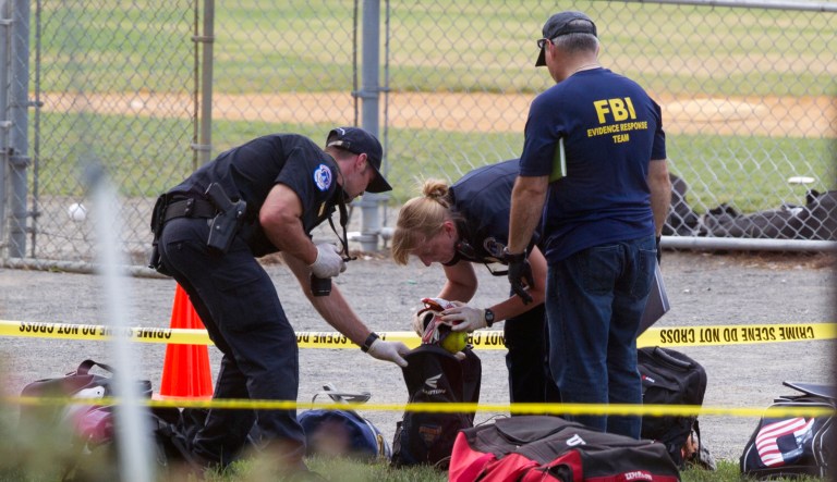 An FBI Evidence Response team inspects the contents of one of the many bags left at the scene of a shooting involving House Majority Whip Steve Scalise of La., and others, during a congressional baseball practice. (AP Photo/Cliff Owen)