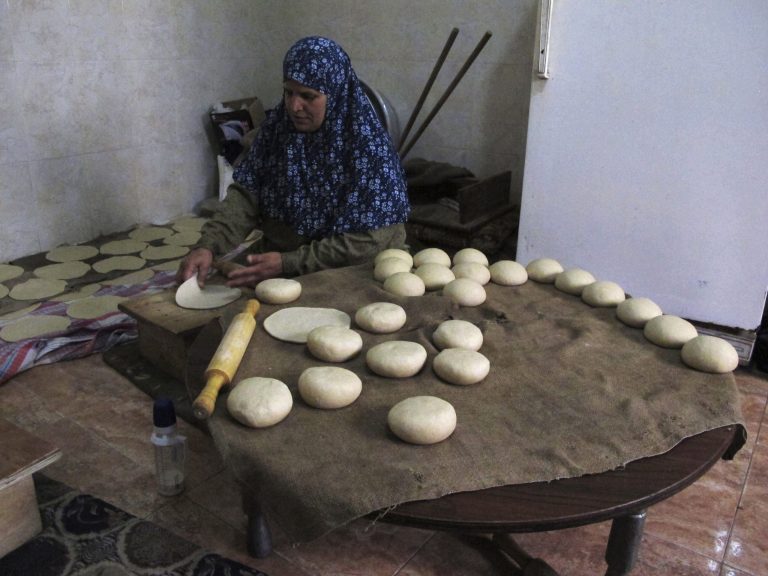 In this Monday, March 18, 2013 photograph, Palestinian Nabila Qishta, 52, prepares bread in the southern Gaza Strip town of Rafah, using flour donated by the U.N. Gaza cuisine is Mediterranean-based, relying on olive oil, fresh vegetables, herbs and grains. 