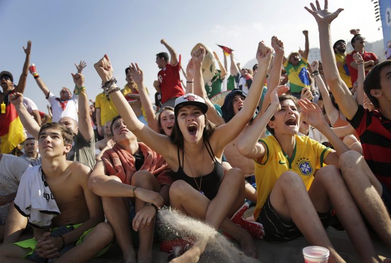 Soccer fans, many supporting Germany, raise their arms and cheer at the FIFA Fan Fest area on Copacabana beach, after Thomas Mueller scored Germany's fourth goal against Portugal on Monday, June 16, 2014  in Rio de Janeiro, Brazil, during Germany's World Cup soccer match with Portugal.(AP Photo/Wong Maye-E)