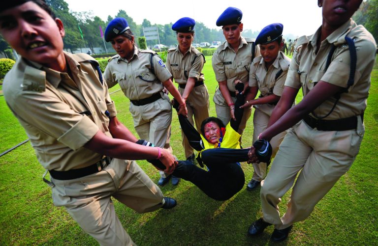 Indian policemen detain a Tibetan Youth Congress (TYC) supporter as she protests outside the Chinese Embassy in New Delhi, India, Monday, Nov. 12, 2012. TYC supporters shouted anti-Chinese government slogans outside the embassy to show support to Tibetans inside China who have set themselves on fire and protested against the Chinese government. (AP Photo/Saurabh Das)