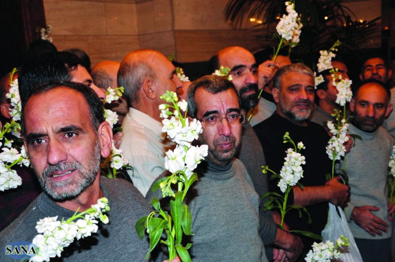 In this photo released by the Syrian official news agency SANA, freed Iranian hostages who were captured by the Syrian rebels since August, hold roses as they gather at a hotel, in Damascus, Syria, Wednesday Jan. 9, 2013. Rebels freed 48 Iranians on Wednesday in exchange for more than 2,000 prisoners, including women and children, held by Syrian authorities -- a deal struck after rare negotiations involving regional powers Turkey, Qatar and Iran. (AP Photo/SANA)