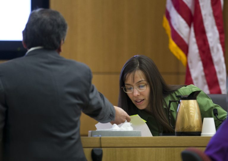 Prosecutor Juan Martinez hands evidence to show Jodi Arias during cross examination during the Jodi Arias trial at Maricopa County Superior Court in Phoenix on Wednesday, Feb. 27, 2013. Arias is charged in the June 2008 death of her lover in his suburban Phoenix home. She says it was self-defense, but police say she planned the attack on Travis Alexander in a jealous rage. (AP Photo/The Arizona Republic, David Wallace, Pool)