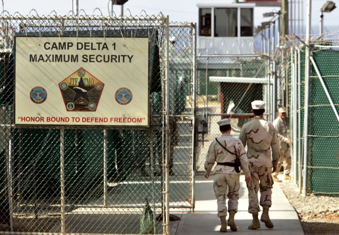 U.S. military guards walk within Camp Delta military-run prison, at the Guantanamo Bay U.S. Naval Base, Cuba. (AP/Brennan Linsley)