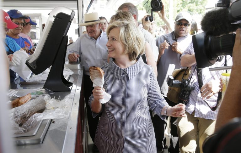 Democratic presidential candidate Hillary Rodham Clinton buys a pork chop during a visit to the Iowa State Fair, Saturday, Aug. 15, 2015, in Des Moines, Iowa. (AP Photo/Charlie Neibergall)