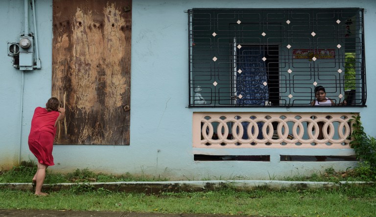 A woman boards up a window in preparation for Hurricane Irma, in Ceiba, Puerto Rico, Wednesday, Sept. 6, 2017. Irma roared into the Caribbean with record force early Wednesday, its 185-mph winds shaking homes and flooding buildings on a chain of small islands along a path toward Puerto Rico, Cuba and Hispaniola and a possible direct hit on densely populated South Florida. (AP Photo/Carlos Giusti)