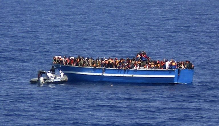 In this photo released by the Italian Navy on Monday, June 30, 2014, and taken on Sunday, June 29, 2014, a motorboat of the Italian Navy approaches a boat of migrants in the Mediterranean Sea. The bodies of some 30 would-be migrants were found in in the hold of a packed smugglers' boat making its way to Italy, the Italian navy said Monday. The boat was carrying nearly 600 people, and the remaining 566 survivors were rescued by the navy frigate Grecale and were headed to the port at Pozzallo, on the southern tip of Sicily. (AP Photo/Italian Navy, ho)