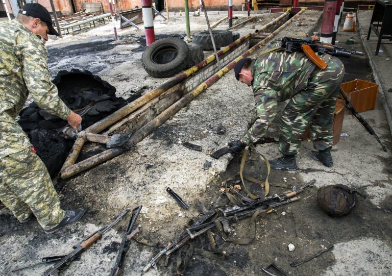 Pro-Russian armed men examine destroyed rifles at a border guards base, which they seized, on the outskirts of Luhansk, Ukraine, Wednesday, June 4, 2014. Pro-Russian insurgents in eastern Ukraine have taken two government bases in battles around Luhansk, seizing quantities of ammunition and explosives from a border guards post and taking another installation after National Guard forces ran out of ammunition. (AP Photo/Igor Golovniov)