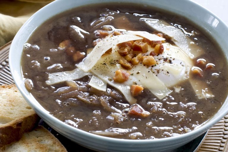   In this image taken on Dec. 20, 2012, Italian-style onion soup topped with a poached egg is shown served in a bowl in Concord, N.H. (AP Photo/Matthew Mead)  