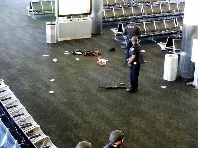 In this Nov. 1, 2013 file photo, police officers stand near a weapon at the Los Angeles International Airport after a gunman opened fire in the terminal, killing one person and wounding several others. (AP)