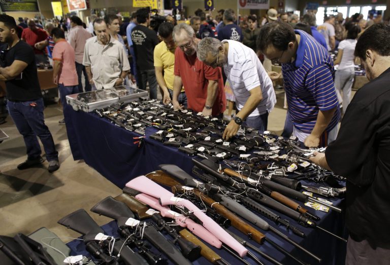 People shop for guns at a gun show hosted by Florida Gun Shows, Saturday, Jan. 9, 2016, in Miami. (AP Photo/Lynne Sladky)