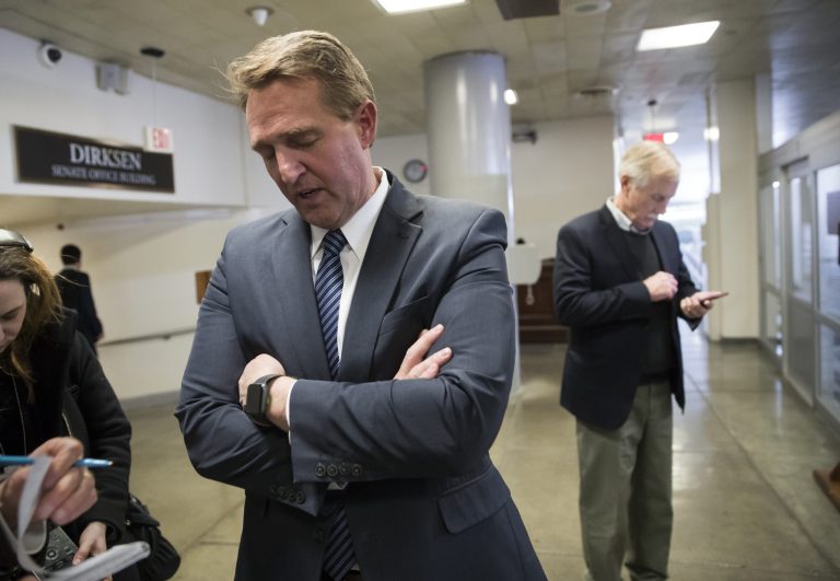 Sen. Jeff Flake, R-Ariz., waits for a subway ride back to the Capitol after he and a bipartisan group of moderate senators, including Sen. Angus King, I-Vt., right, met privately on Day 2 of the federal shutdown, at the Capitol in Washington, Sunday, Jan. 21, 2018. (AP Photo/J. Scott Applewhite)