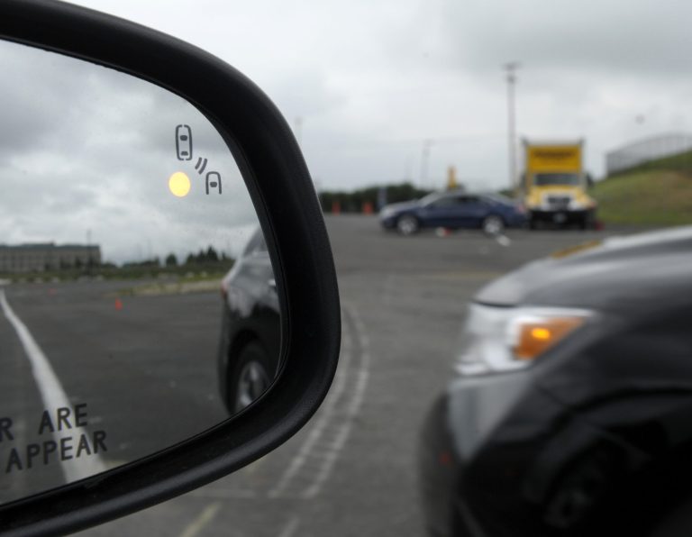 FILE - This May 22, 2012 file photo shows a demonstration of a side mirror warning signal in a Ford Taurus at an automobile testing area in Oxon Hill, Md. The Obama administration said Monday it is taking a first step toward requiring that future cars and light trucks be equipped with technology that enables them to warn each other of potential danger in time to avoid collisions. A research report released by the National Highway Traffic Safety Administration estimates that the technology could eventually prevent 592,000 left-turn and  intersection crashes a year, saving 1,083 lives. The agency said it will begin drafting rules to require the technology in new vehicles.  (AP Photo/Susan Walsh, File)