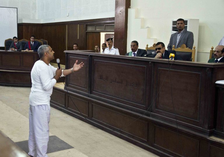 Canadian-Egyptian acting Al-Jazeera bureau chief Mohammed Fahmy talks to the judge in the Police Academy courthouse along with several other defendants during their trial on terror charges in Cairo, Egypt, Saturday, May 3, 2014. Fahmy made a rare appeal to the judge from outside of the defendants' cage, at the end of which the judge wished him a 