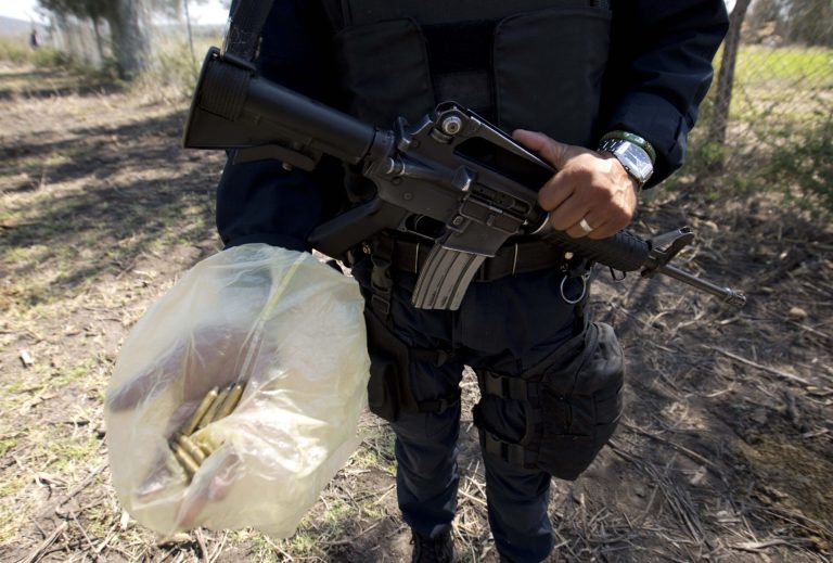 A police officers shows casings he gathered just outside the fence line of Rancho del Sol, a ranch that was the site of clashes between Mexican authorities and a drug cartel, in the municipality of Ecuandureo, Mexico, Saturday, May 23, 2015. (AP Photo/Eduardo Verdugo)