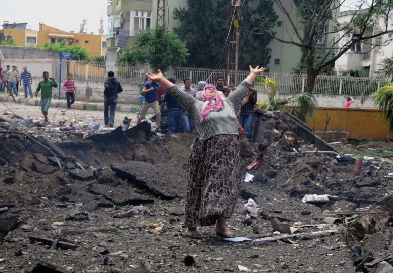 A woman cries at the scene of one of the explosion sites, after several explosions killed at least 18 people and injured dozens in Reyhanli, near Turkey's border with Syria, Saturday, May 11, 2013, Turkish Interior Minister Muammer Guler said.(AP Photo/Anadolu Agency, Cem Genco) TURKEY OUT