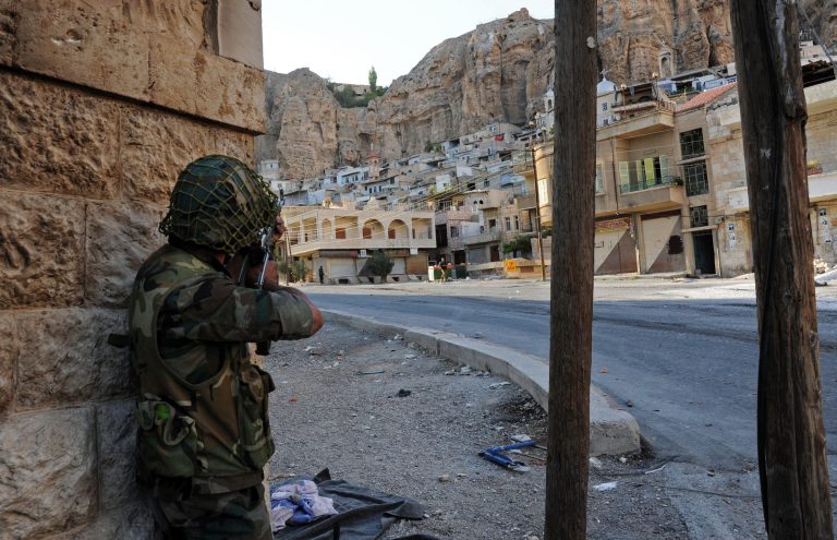 A Syrian government solider aims his weapon during clashes with Free Syrian Army fighters in Maaloula village, northeast of the capital Damascus, Syria. (AP/SANA)