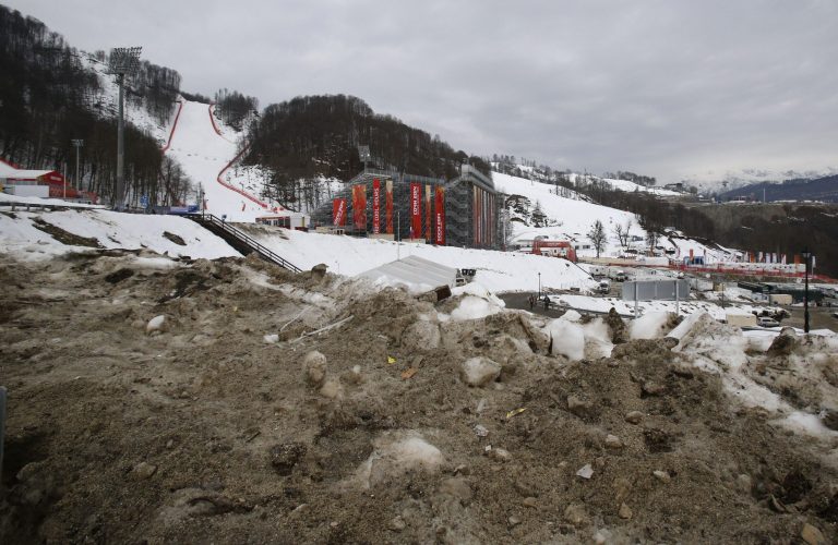 Brown, dirty snow is piled up on the road to the finish area of the alpine ski venue at the Sochi 2014 Winter Olympics, Tuesday, Feb. 11, 2014, in Krasnaya Polyana, Russia. Warm temperatures in the mountains was a factor in the cancellation of Women's downhill training on Tuesday.  (AP Photo/Christophe Ena)