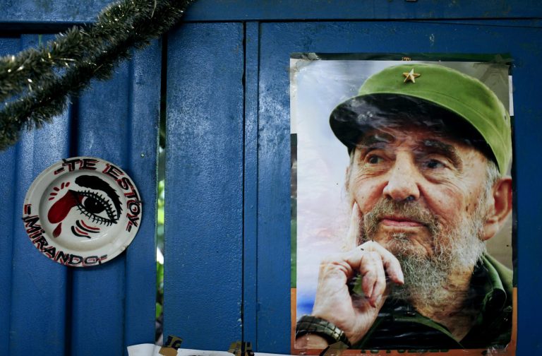 A poster of Cuba's Fidel Castro hangs on the wall of a food market next to plate that reads in Spanish 