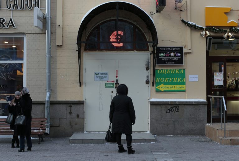 A woman stands in front of an exchange office in Moscow, Russia, Monday. (AP/Ivan Sekretarev)