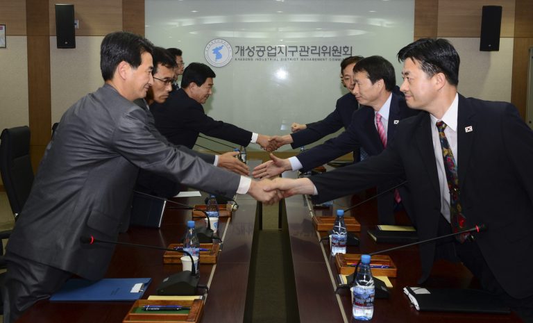   In this photo released by Unification Ministry, South Korean delegates, right, shake hands with their North Korean counterparts at the start of a meeting at Kaesong Industrial District Management Committee in Kaesong, North Korea, Wednesday, Sept. 11, 2013. Both Koreas agreed Wednesday to restart operations at a jointly run factory park that Pyongyang shut down in April during a torrent of threats, the latest sign of easing animosity between the rivals. (AP Photo/Unification Ministry)  