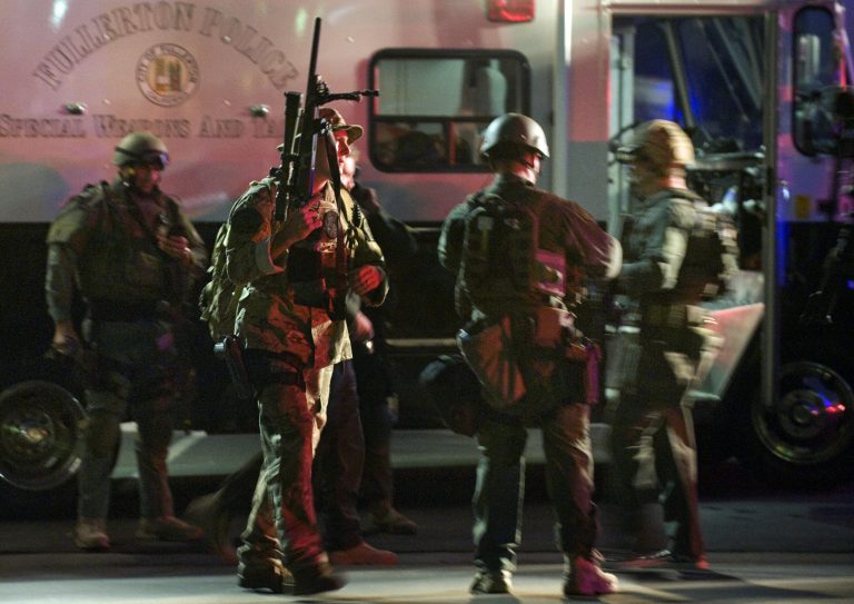   SWAT team members form up near a command post south of the Cal State Fullerton campus, Wednesday, Dec. 12, 2012, in Fullerton, Calif. Students were placed on lock down as police searched for two suspects in a jewelry store robbery, who were considered armed and dangerous. (AP Photo/The Orange County Register, Bruce Chambers)  