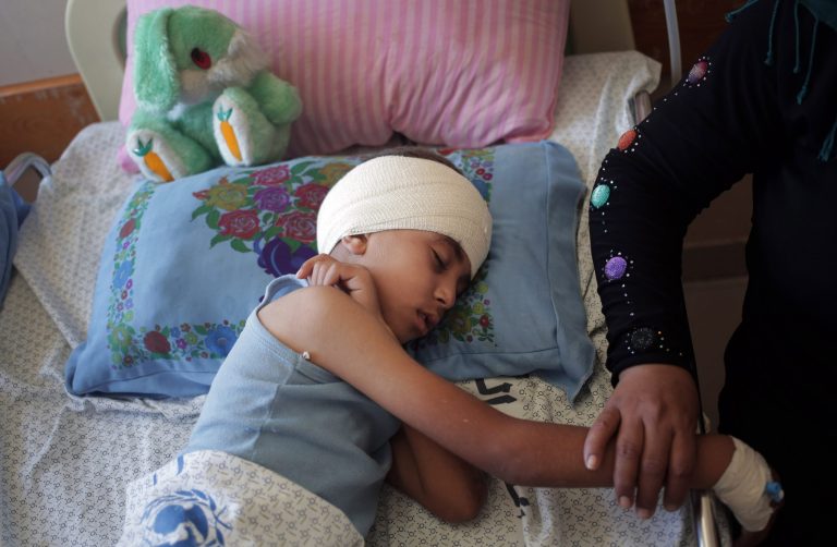 In this Thursday, July 24, 2014 photo, Mojahed al-Ejla, 8, rests at the Shifa hospital where he is receiving treatment for a fractured skull caused by a July 19 Israeli shelling while he and the family were fleeing from the Shijaiyah neighborhood, in Gaza City. The pediatrics wing of the largest hospital in the Gaza Strip is filled with the youngest victims of more than two weeks of Israel-Hamas fighting. (AP Photo/Khalil Hamra)